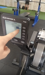 The best home rowing machine, the Concept 2 Model D Rower: finger pointing at the tracking screen