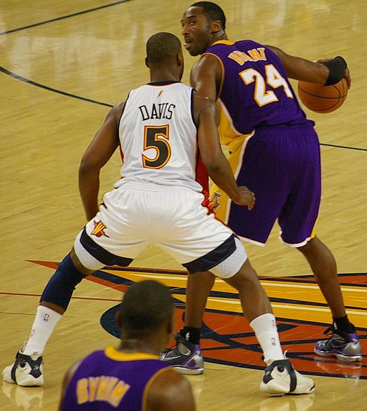 Basket ball player wearing a knee compression sleeve on left leg